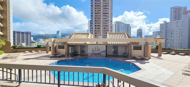 community pool with a city view and a patio