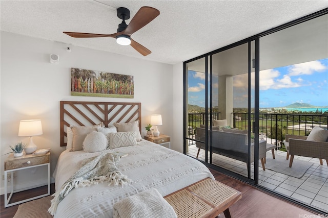 322 Aoloa St Unit 1403, Kailua, HI 96734 - bedroom with a mountain view, expansive windows, access to outside, wood finished floors, and a textured ceiling