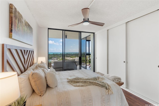 322 Aoloa St Unit 1403, Kailua, HI 96734 - bedroom with access to exterior, a textured ceiling, dark wood finished floors, a wall of windows, and a ceiling fan