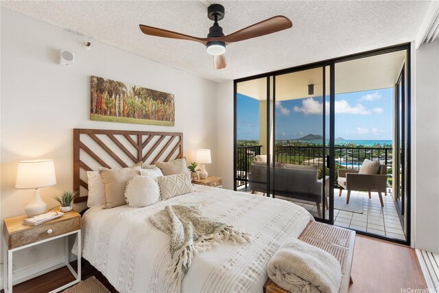 322 Aoloa St Unit 1403, Kailua, HI 96734 - bedroom with expansive windows, access to exterior, a textured ceiling, wood finished floors, and a ceiling fan