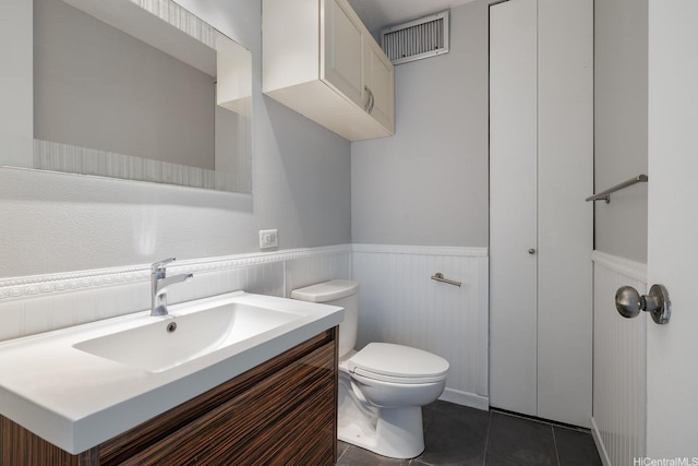 2452 Tusitala St Unit 1610, Honolulu, HI 96815 - bathroom with a wainscoted wall, toilet, vanity, and tile patterned floors