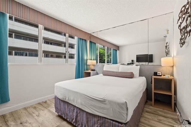 444 Kanekapolei St Unit 208, Honolulu, HI 96815 - bedroom featuring wood finished floors, a textured ceiling, and baseboards