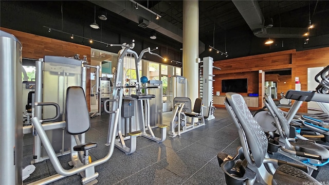 exercise room featuring wood walls and track lighting