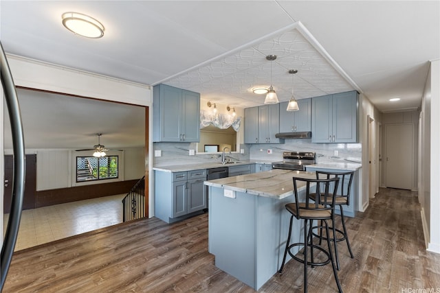 1328 Hele St, Kailua, HI 96734 - kitchen with appliances with stainless steel finishes, under cabinet range hood, decorative backsplash, and a breakfast bar