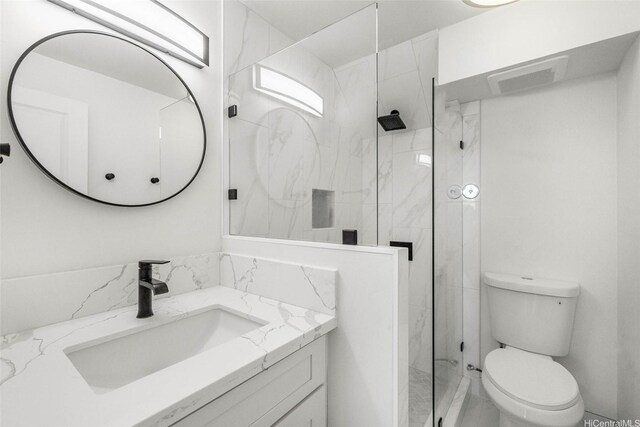 full bathroom with toilet, a marble finish shower, marble finish flooring, and vanity