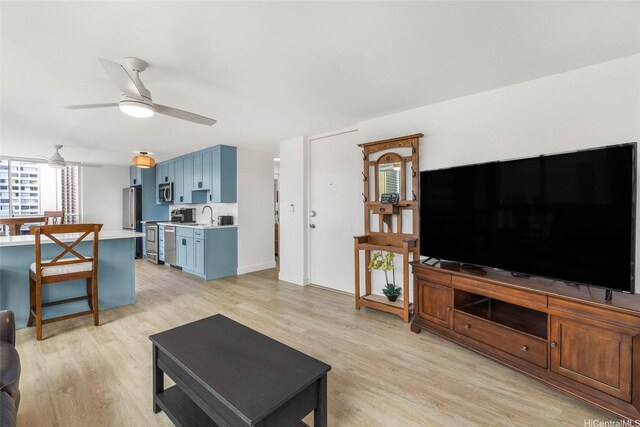 living area featuring light wood-style floors and a ceiling fan