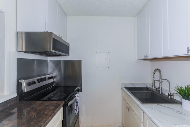 98-1038 Moanalua Rd Unit 1905, Aiea, HI 96701 - kitchen with appliances with stainless steel finishes, a sink, white cabinets, dark stone countertops, and a textured ceiling