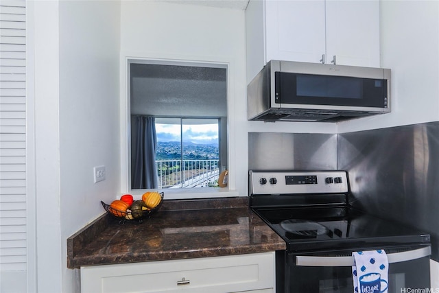 98-1038 Moanalua Rd Unit 1905, Aiea, HI 96701 - kitchen featuring appliances with stainless steel finishes, white cabinetry, and dark stone countertops