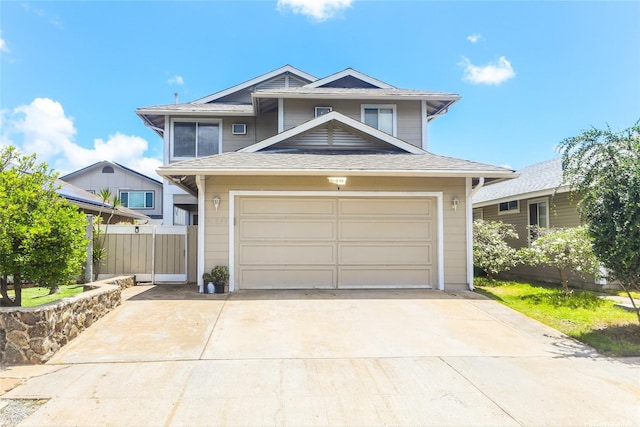 traditional-style house with driveway, fence, and an attached garage