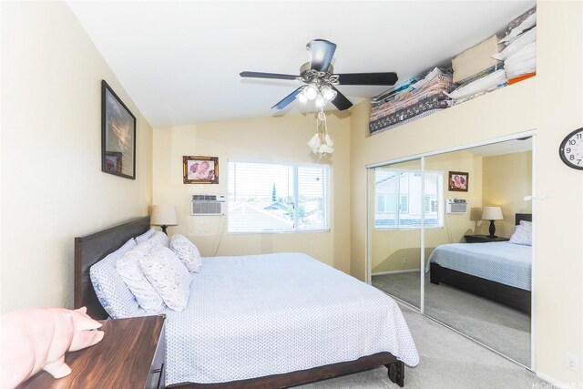 carpeted bedroom with a closet, lofted ceiling, ceiling fan, baseboards, and a wall mounted air conditioner