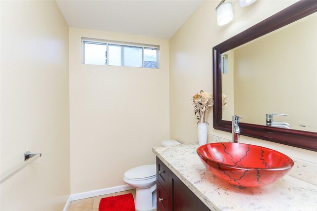 bathroom with vanity, toilet, tile patterned floors, and baseboards
