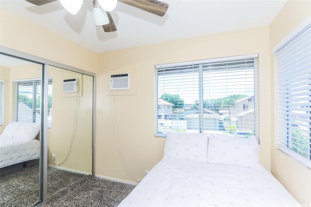 bedroom featuring an AC wall unit, a closet, carpet flooring, and ceiling fan