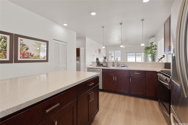 91-1139 Iliahialoe Loop, Ewa Beach, HI 96706 - kitchen featuring a sink, appliances with stainless steel finishes, light stone countertops, hanging light fixtures, and a peninsula
