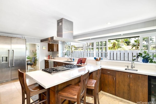 49 Pilipu Pl, Kailua, HI 96734 - kitchen featuring appliances with stainless steel finishes, island range hood, beverage cooler, a sink, and light countertops