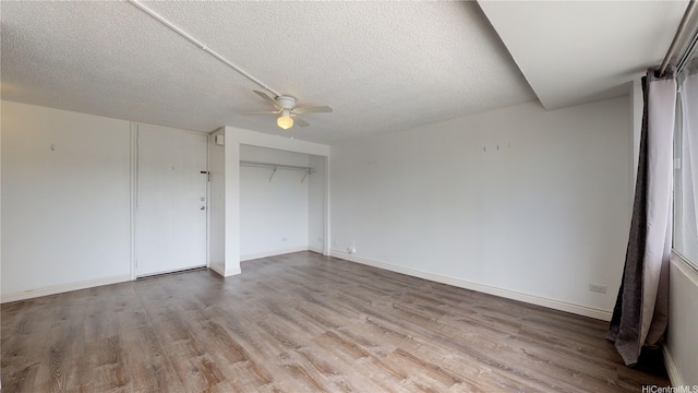 2888 Ala Ilima St Unit 512, Honolulu, HI 96818 - unfurnished bedroom featuring light wood-style flooring, a textured ceiling, baseboards, ceiling fan, and a closet