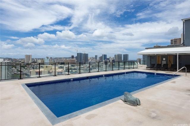 community pool featuring a skyline view and a patio area
