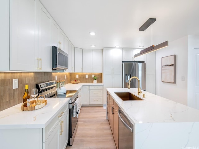 45-630 Liula St, Kaneohe, HI 96744 - kitchen with appliances with stainless steel finishes, a sink, an island with sink, backsplash, and white cabinetry