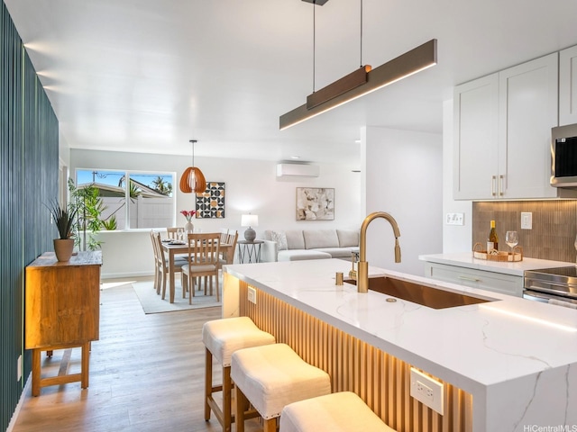 45-630 Liula St, Kaneohe, HI 96744 - kitchen with a sink, light wood-type flooring, tasteful backsplash, white cabinets, and light stone countertops