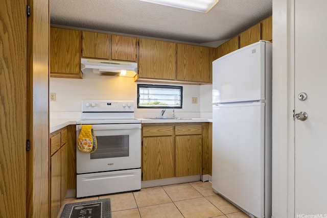 kitchen featuring under cabinet range hood, white appliances, light countertops, a textured ceiling, and a sink