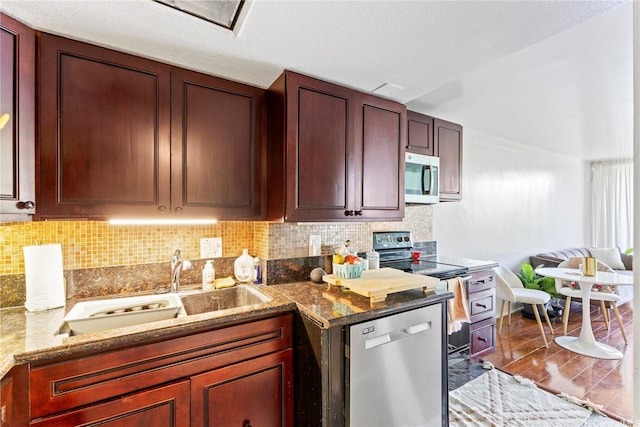 440 Seaside Ave Unit 404, Honolulu, HI 96815 - kitchen with stainless steel appliances, tasteful backsplash, light stone counters, a sink, and wood finished floors