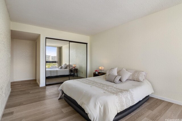 300 Wai Nani Way Unit 1902, Honolulu, HI 96815 - bedroom with wood finished floors, a closet, a textured ceiling, and baseboards