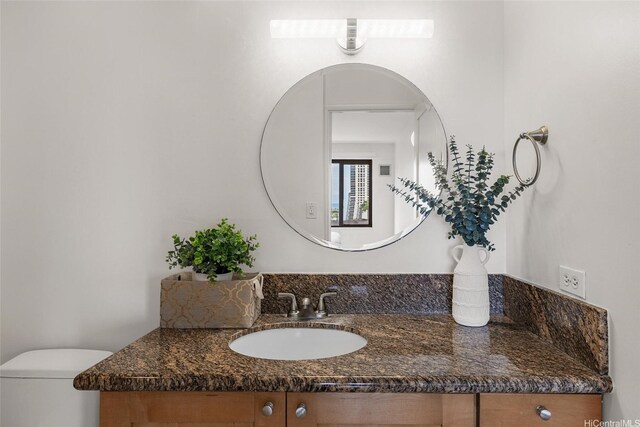 half bathroom featuring vanity and toilet