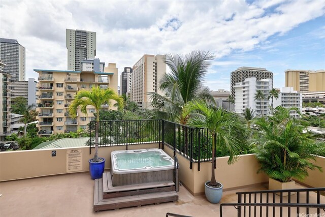 balcony featuring an outdoor hot tub and a view of city