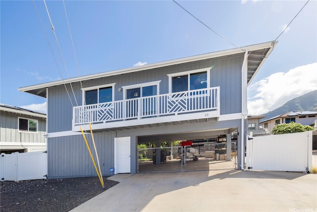 view of front facade with a gate, a carport, driveway, and fence
