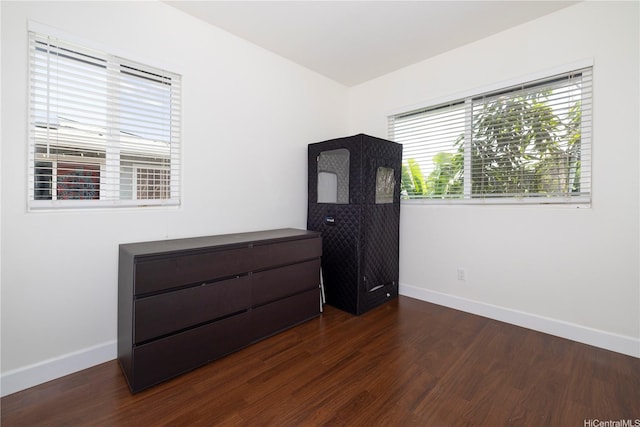 empty room with baseboards and dark wood finished floors
