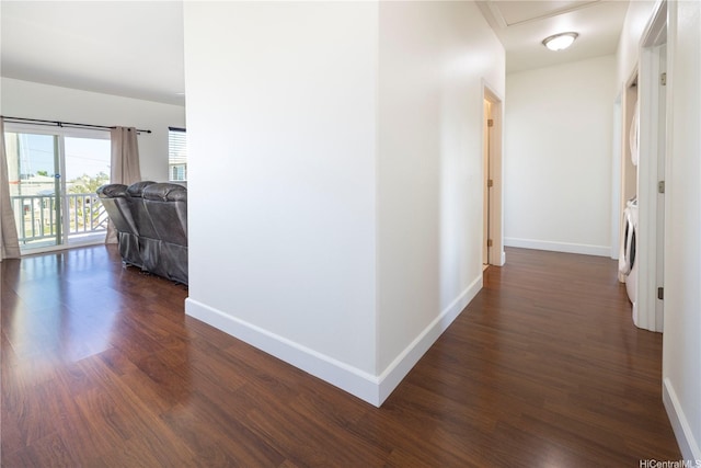 hall featuring baseboards, dark wood-style flooring, and washer / clothes dryer