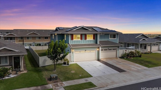 91-3390 Maohiohi Loop, Ewa Beach, HI 96706 - view of front of home with board and batten siding, a garage, solar panels, and concrete driveway
