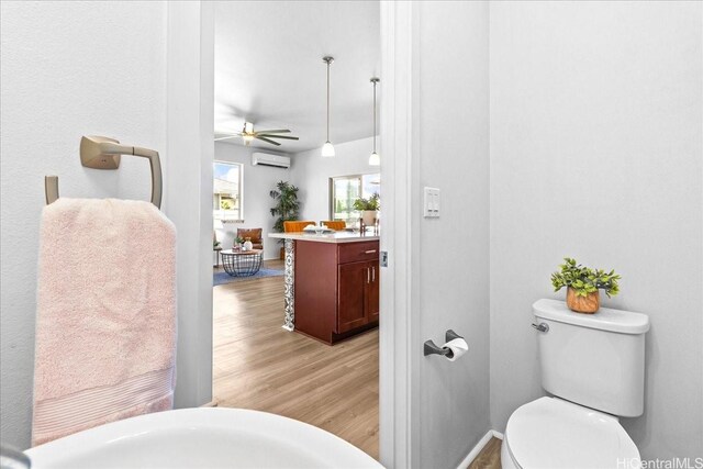 91-3390 Maohiohi Loop, Ewa Beach, HI 96706 - bathroom featuring wood finished floors, a wall mounted air conditioner, a ceiling fan, toilet, and vanity