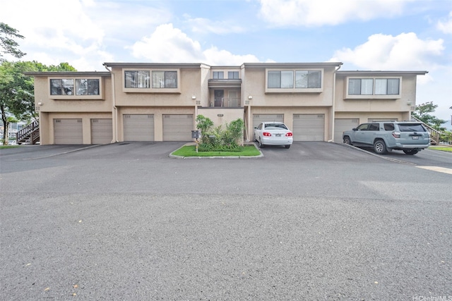 46-010 Aliikane Pl Unit 211, Kaneohe, HI 96744 - view of property with stucco siding, an attached garage, and driveway