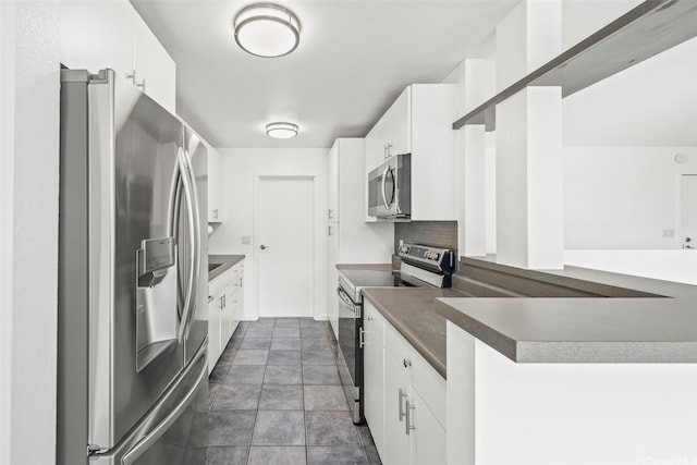 46-010 Aliikane Pl Unit 211, Kaneohe, HI 96744 - kitchen with appliances with stainless steel finishes, white cabinets, dark countertops, dark stone finish flooring, and a peninsula