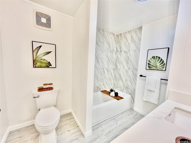 bathroom featuring wood finished floors, a sink, toilet, and baseboards