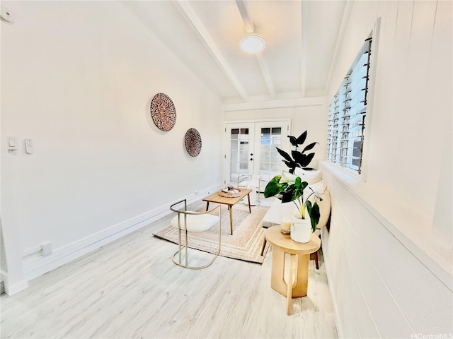 living area with beamed ceiling, wood finished floors, french doors, and baseboards
