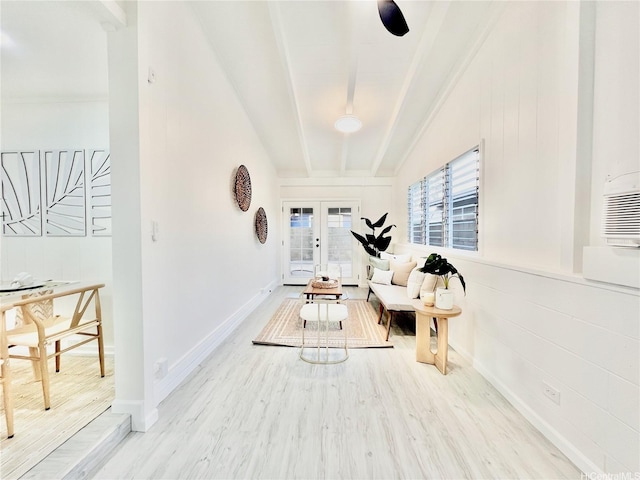 living area with french doors, wood finished floors, and lofted ceiling