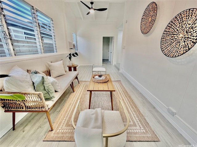 living room featuring wood finished floors, baseboards, and a ceiling fan