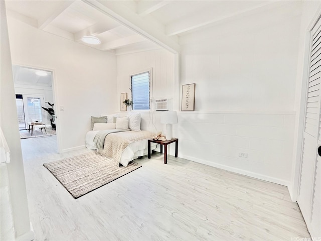 bedroom featuring beam ceiling and wood finished floors