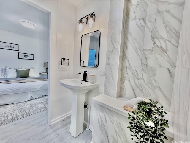 bathroom with ensuite bath and wood finished floors