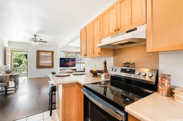 1506 Frear St Unit A, Honolulu, HI 96813 - kitchen with stainless steel electric stove, under cabinet range hood, open floor plan, a peninsula, and light brown cabinetry