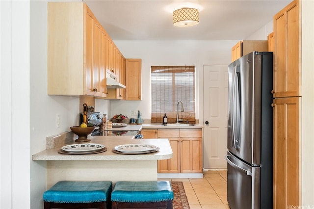 kitchen featuring freestanding refrigerator, a sink, electric stove, a peninsula, and light countertops