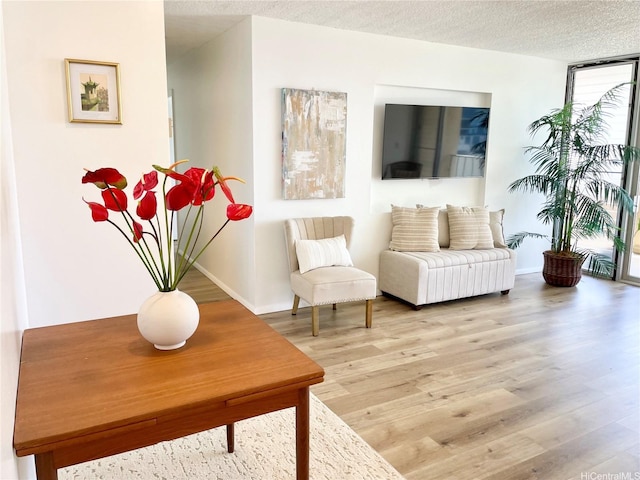 1561 Kanunu St Unit 1206, Honolulu, HI 96814 - sitting room with light wood-type flooring, baseboards, and a textured ceiling