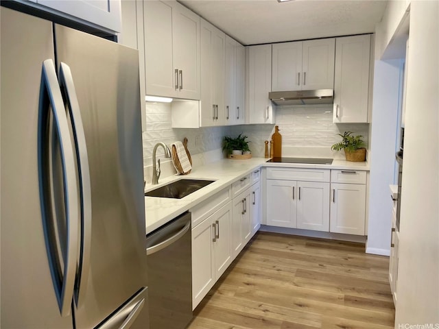 1561 Kanunu St Unit 1206, Honolulu, HI 96814 - kitchen featuring appliances with stainless steel finishes, a sink, white cabinets, under cabinet range hood, and backsplash
