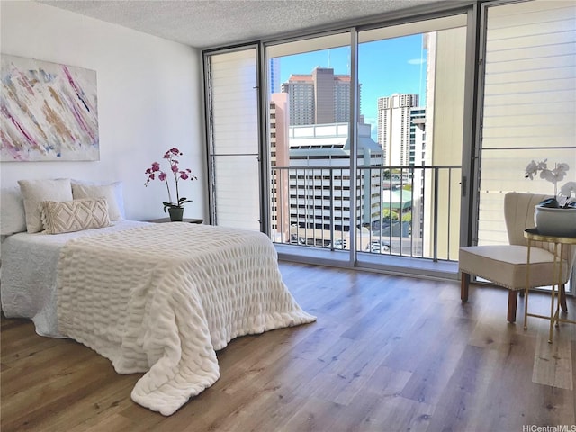 1561 Kanunu St Unit 1206, Honolulu, HI 96814 - bedroom featuring expansive windows, access to outside, a textured ceiling, wood finished floors, and a city view