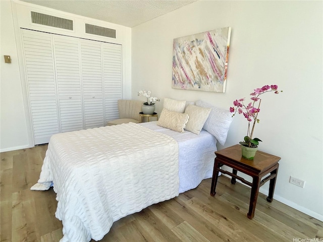 1561 Kanunu St Unit 1206, Honolulu, HI 96814 - bedroom featuring wood finished floors, a closet, baseboards, and a textured ceiling