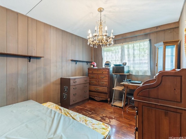 bedroom featuring wood finished floors, a chandelier, wooden walls, and a desk