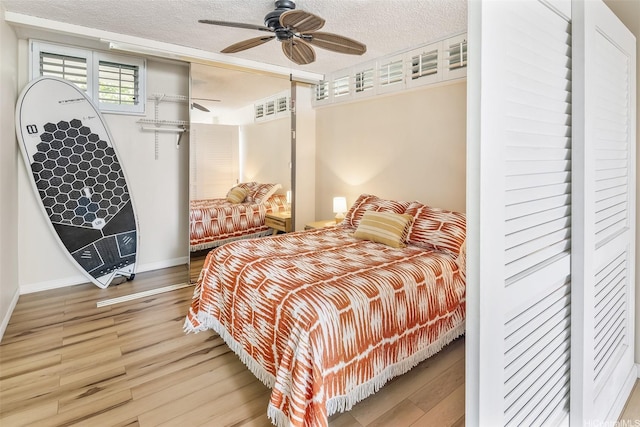 2801 Coconut Ave Unit 2G, Honolulu, HI 96815 - bedroom with wood finished floors, baseboards, a textured ceiling, and ceiling fan
