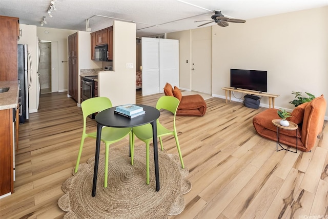 2801 Coconut Ave Unit 2G, Honolulu, HI 96815 - living area featuring light wood-style floors, ceiling fan, rail lighting, and baseboards