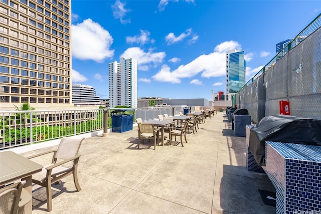 view of patio / terrace with outdoor dining area, grilling area, and a view of city